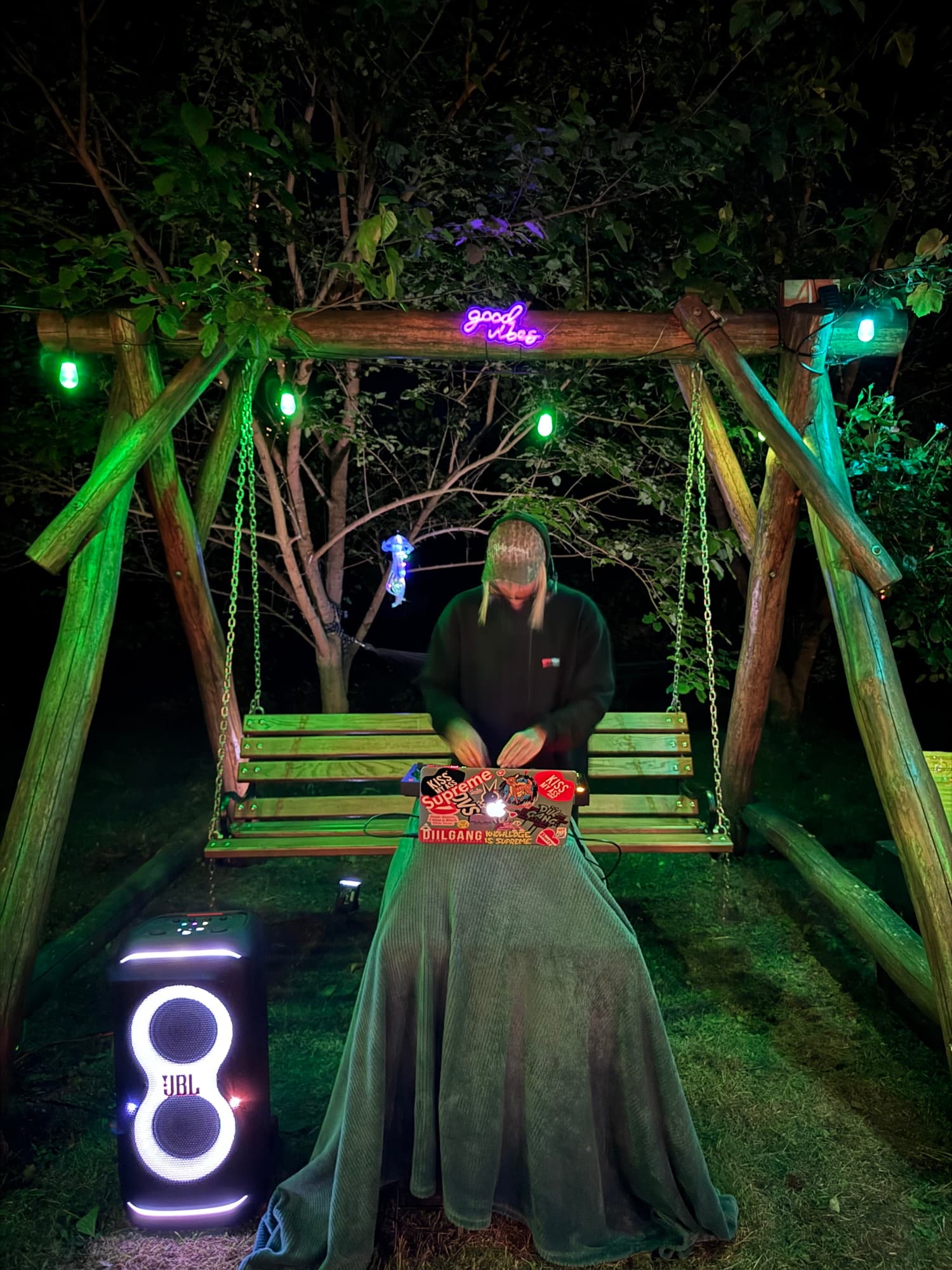 Hustawka ogrodowa nocą z glosnikiem JBL i neonowym napisem