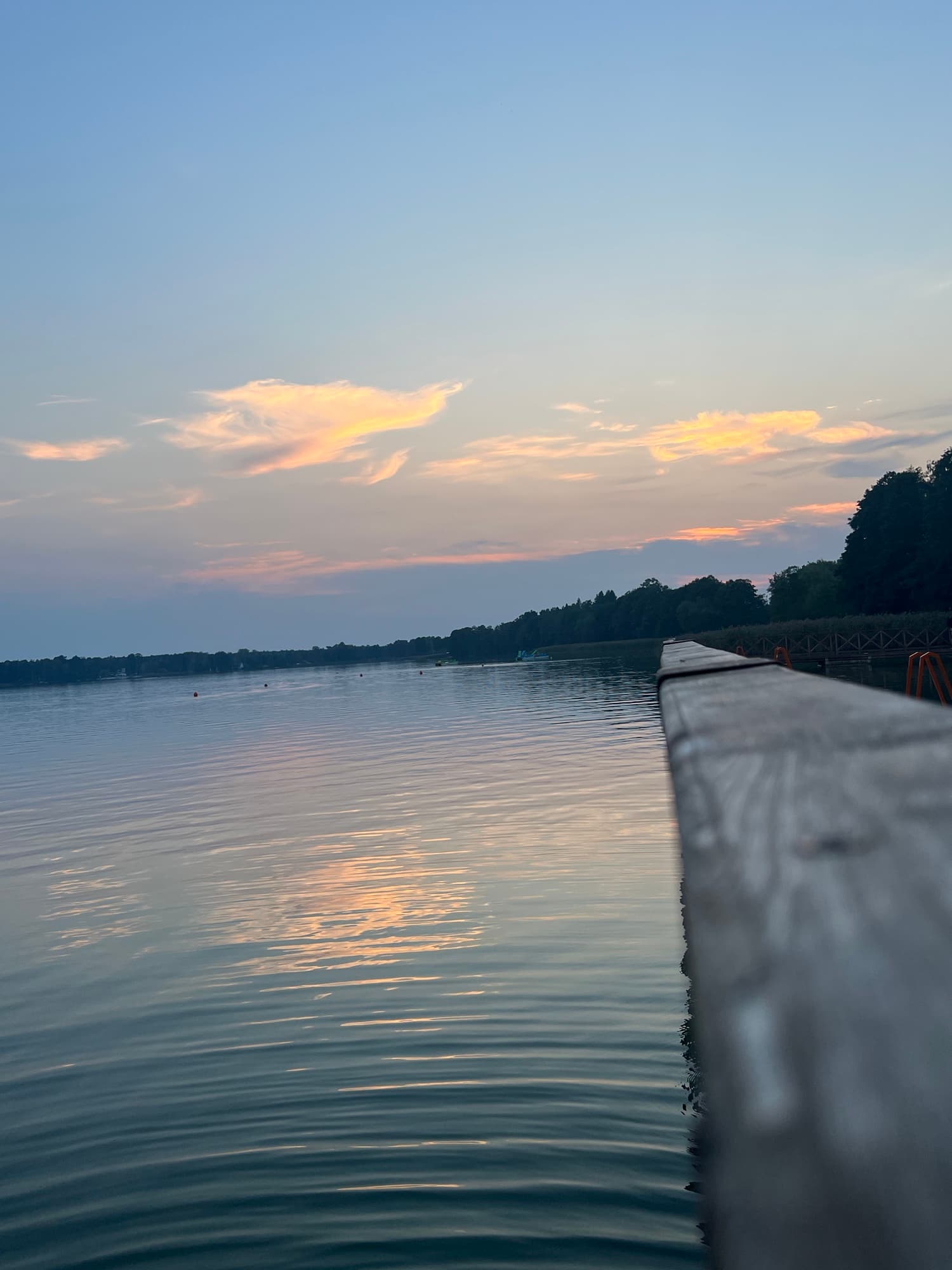 Jezioro o zachodzie slonca — dlug pomost i spokojna woda