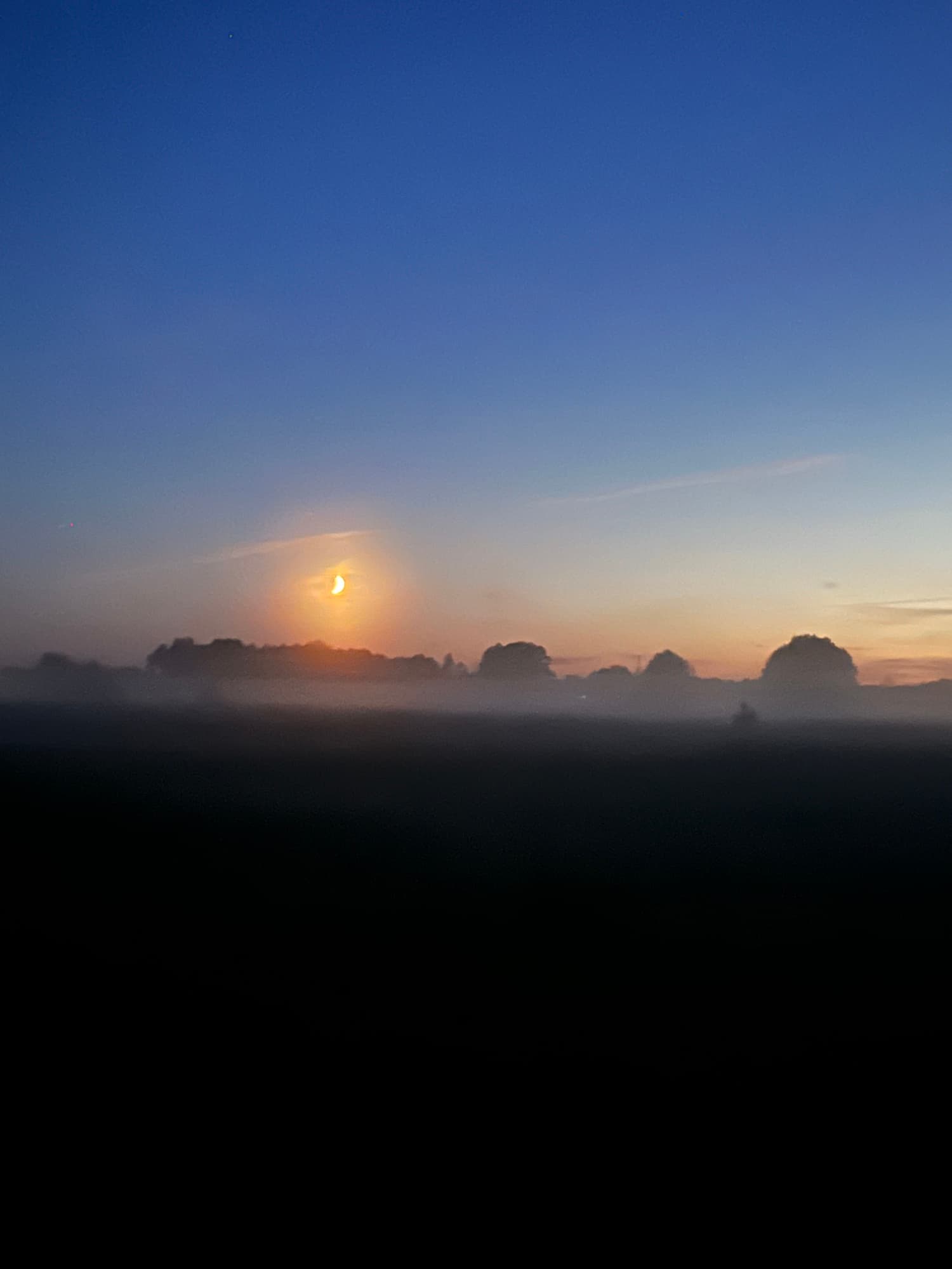 Wschod ksiezyca nad zamglonymi polami o swicie