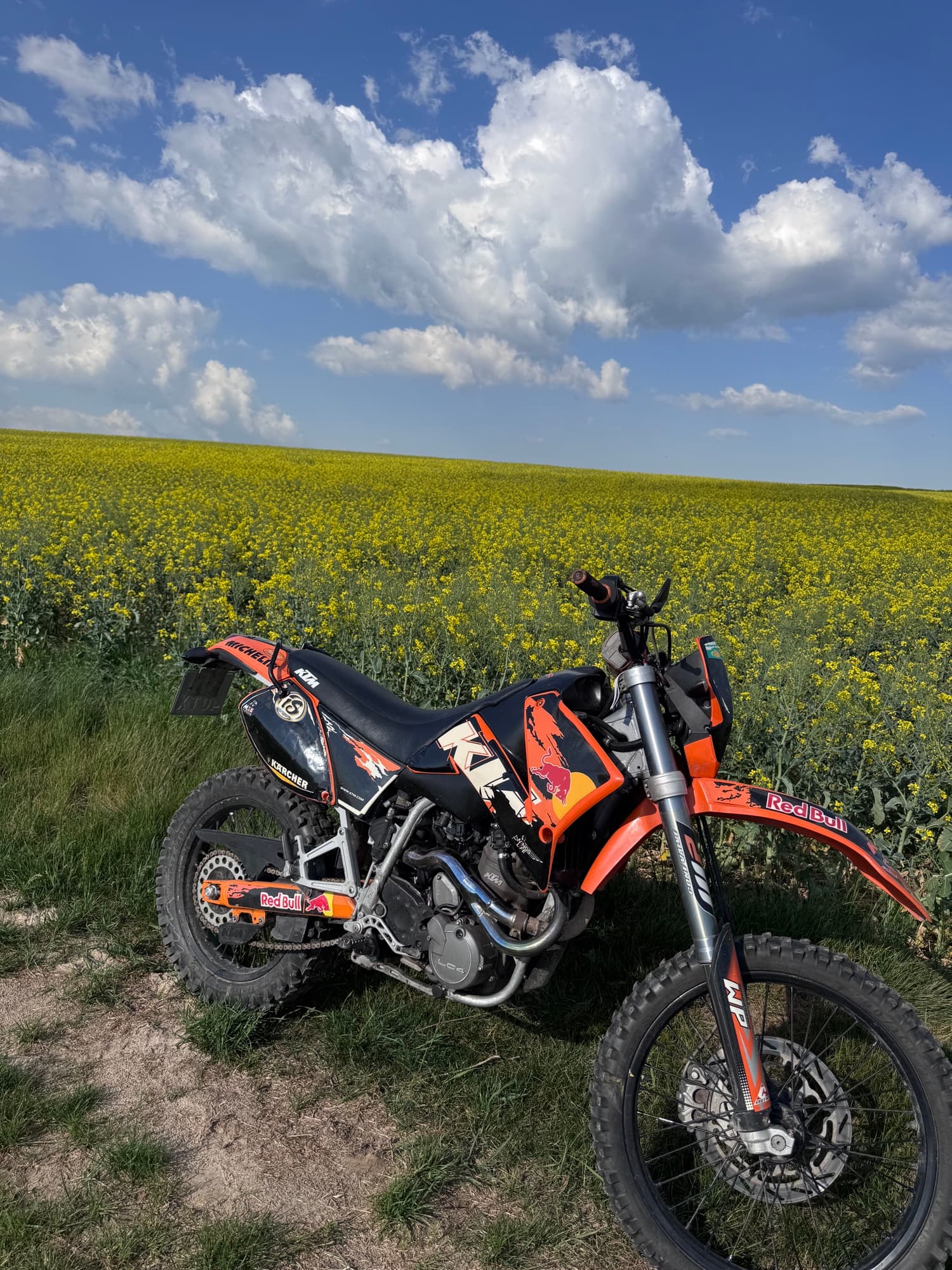 Motocykl KTM na tle rzepaku i bialych chmur